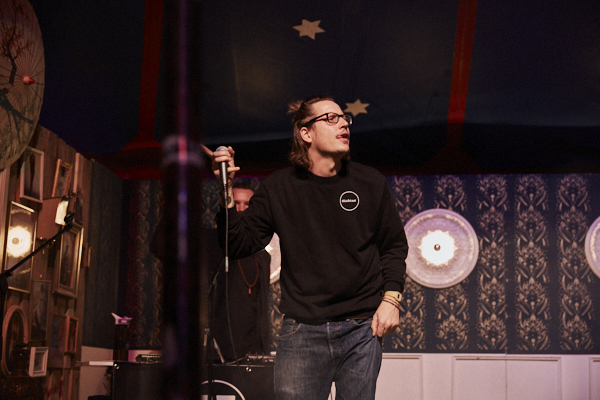 Münchner Rapper dichter bei einem Auftritt auf der Bühne. 